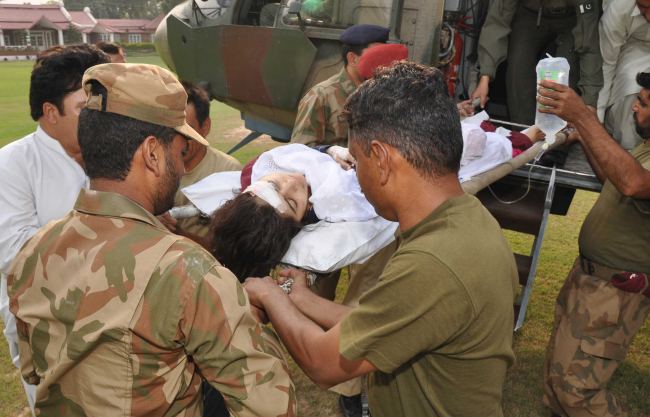 Pakistani soldiers carry wounded Pakistani girl, Malala Yousufzai, from a military helicopter to a military hospital in Peshawar, Pakistan, Tuesday.   AP-Yonhap News