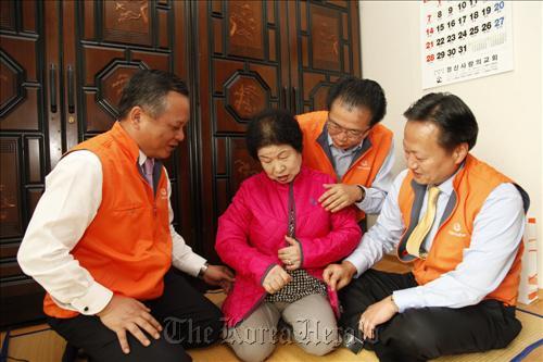 Hanwha Group executives deliver a padded jacket during their visit to a senior citizen who lives alone in Seoul on Tuesday.   Hanwha Group