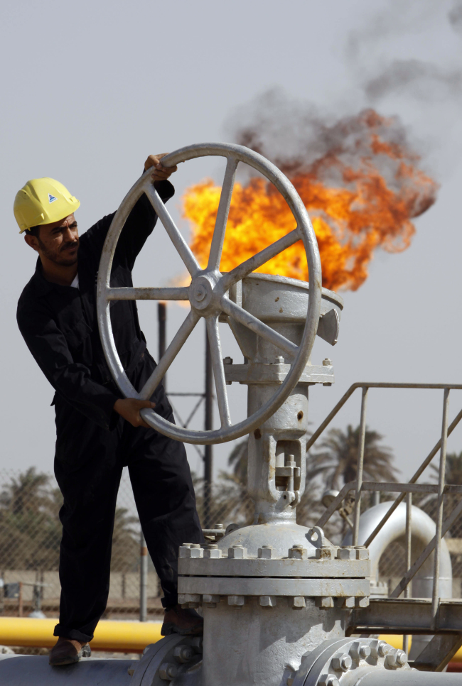 <YONHAP PHOTO-2000> FILE - In this file photo of Friday, July 17, 2009, an Iraqi worker operates valves at the Nahran Omar oil refinery near the city of Basra, 340 miles (550 kilometers) southeast of Baghdad, Iraq. The International Energy Agency predicted Tuesday Oct. 9, 2012 that Iraq will consolidate its position as a global oil power _ allowing it to rebuild the economy of a nation ravaged by war and decades of Saddam Hussein?s autocratic rule. The leading global energy monitor reported that Iraq?s annual revenues from energy exports could double to an average of $200 billion annually over the next 20 years. That optimistic scenario would make Iraq?s economy the same size as that of Saudi Arabia now by 2035. (AP Photo/Nabil al-Jurani, File)/2012-10-09 20:57:32/ <저작권자 ⓒ 1980-2012 ㈜연합뉴스. 무단 전재 재배포 금지.>
A worker operates valves at the Nahran Omar oil refinery near Basra, Iraq.   AP-Yonhap News