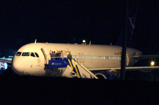 <YONHAP PHOTO-0274> People gather atop the aircraft steps at a Syrian passenger plane that was forced by Turkish jets to land at Esenboga airport in Ankara, Turkey, Wednesday, Oct. 10, 2012. Turkish jets on Wednesday forced a Syrian Air Airbus A320 passenger plane to land at Ankara airport on suspicion that it may be carrying weapons, Turkey's Foreign Minister Ahmet Davutoglu said, amid heightened tensions between Turkey and Syria that have sparked fears of a wider regional conflict.(AP Photo/Burhan Ozbilici)/2012-10-11 06:08:15/ <저작권자 ⓒ 1980-2012 ㈜연합뉴스. 무단 전재 재배포 금지.>
People gather atop the aircraft steps at a Syrian passenger plane that was forced by Turkish jets to land at Esenboga airport in Ankara on Wednesday.   AP-Yonhap News