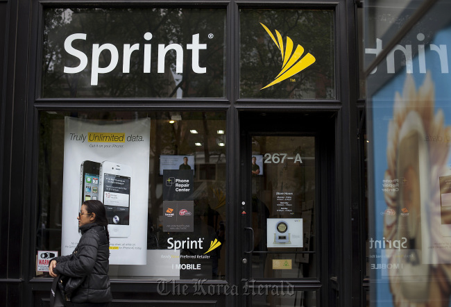 A pedestrian passes in front a Sprint Nextel Corp. store in New York. Bloomberg