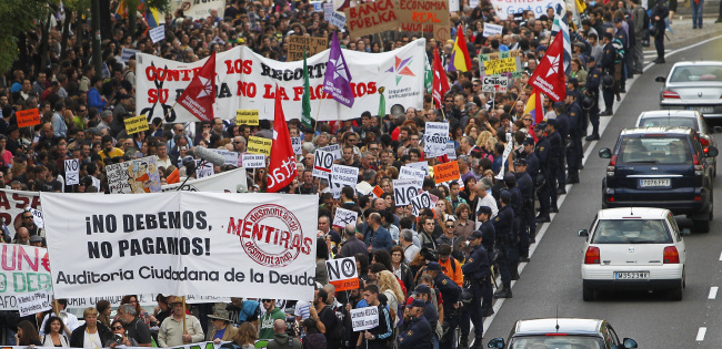 Protestor march as they hold banners reading “We don’t owe, we won’t pay” against austerity measures announced by the Spanish government in Madrid on Saturday.   AP-Yonhap News