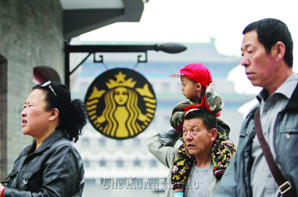 A Starbucks sign is seen in Qianmen, Beijing. The increasing interest of the Chinese consumers for coffee has created huge opportunities for coffee chains and equipment makers.   China Daily