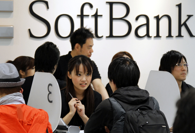 Softbank Corp. employees tend customers who purchased Apple’s new tablet device iPads at a Softbank store in Tokyo.   AP-Yonhap News
