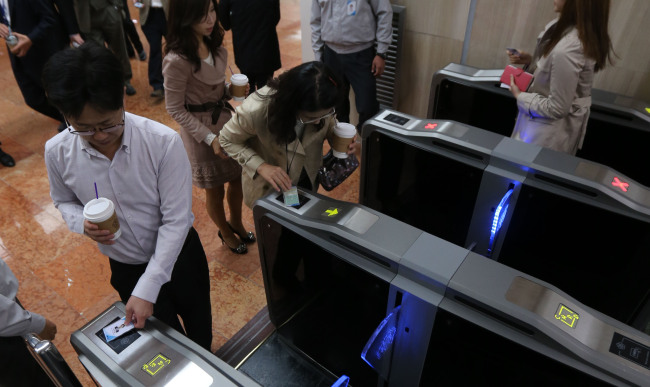 Public officials pass through electronic gates at the Central Government Complex on Monday.   Yonhap News