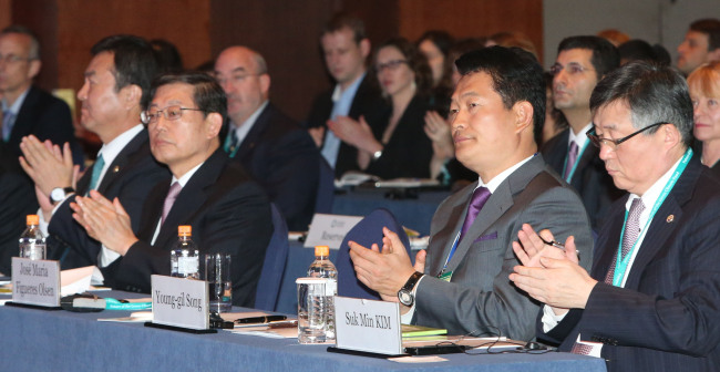 <YONHAP PHOTO-1140> 송영길 인천시장, GCF 국제포럼 개회식 참석 (서울=연합뉴스) 하사헌 기자 = 송영길 인천시장이 16일 오전 서울 강남구 삼성동 그랜드인터컨티넨탈 호텔에서 열린 유엔 녹색기후기금(GCF) 국제포럼 개회식에 참석, 박수치고 있다. 2012.10.16 toadboy@yna.co.kr/2012-10-16 14:23:38/ <저작권자 ⓒ 1980-2012 ㈜연합뉴스. 무단 전재 재배포 금지.>
Incheon Mayor Song Young-gil (second from right) and Prime Minister Kim Hwang-sik (third from right) attended the Global Climate Fund International Forum in Seoul on Tuesday. (Related stories on Page 4)   Yonhap News
