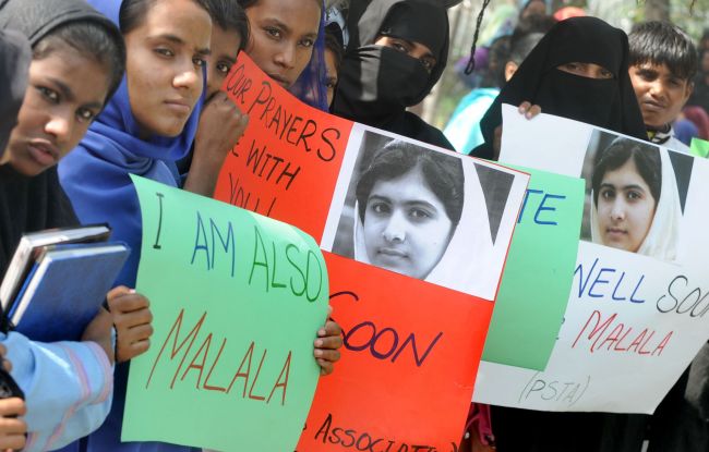 Pakistani students carry placards with the photograph of child activist Malala Yousafzai during a protest against the assassination attempt by the Taliban on Malala in Lahore on Tuesday.   AFP-Yonhap News