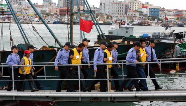 Chinese fishermen are taken by coast guards in Mokpo Harbor on Tuesday.   Yonhap News