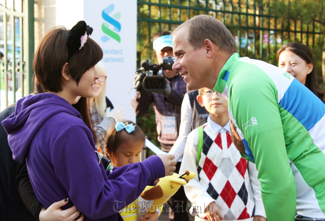 Standard Chartered Korea chief executive Richard Hill meets with blind children and NGO members during the bank’s “Here for Good” event held Saturday at Everland in Yongin, Gyeonggi Province.   Standard Chartered