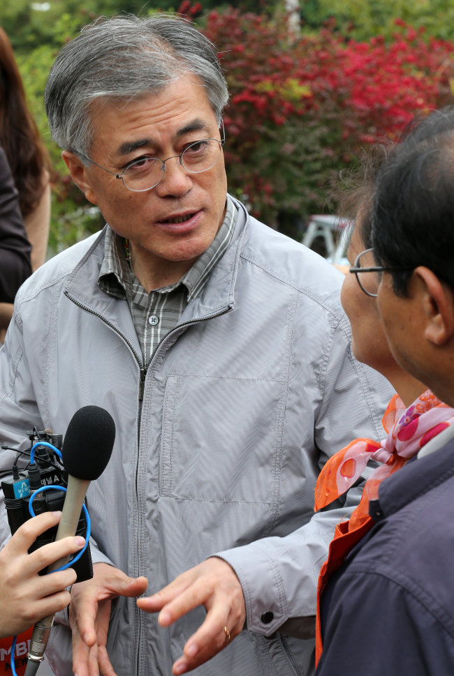 Democratic United Party presidential candidate Moon Jae-in talks to farmers in Eumseong County, North Chungcheong Province, Wednesday.   Yonhap News