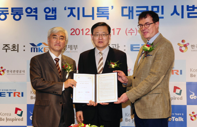 Knowledge Economy Minister Hong Suk-woo (center) poses with ETRI President Kim Heung-nam (left) and Korea Tourism Organization CEO Lee Charm after signing an MOU with KTO for pilot services of GenieTalk, an app for Korea-English translation,  in Seoul on Wednesday.   Yonhap News
