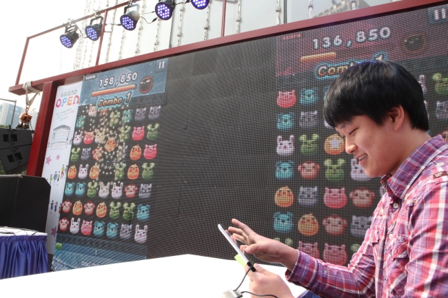 A player shows off his skills in an “Anipang” mobile game compeition in front of Lotte Department Store in Seoul earlier this month.   Yonhap News