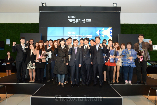 NHN Corp. chief executive Kim Sang-hun (front row, second from left) and four judges stand with awardees at the closing of the NHN Game Literary Award 2012 in Seoul on Thursday.   NHN Corp.