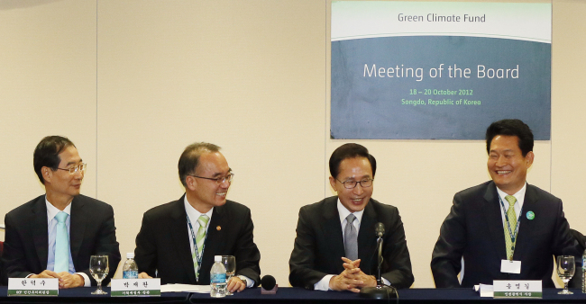 President Lee Myung-bak (left) and Incheon City mayor Song Young-gil smile in a press conference to announce the luring of the headquarters of the Green Climate Fund to Sondgo, Incheon. The press conference was held in the Songdo Convention Center on Saturday.   Yonhap News