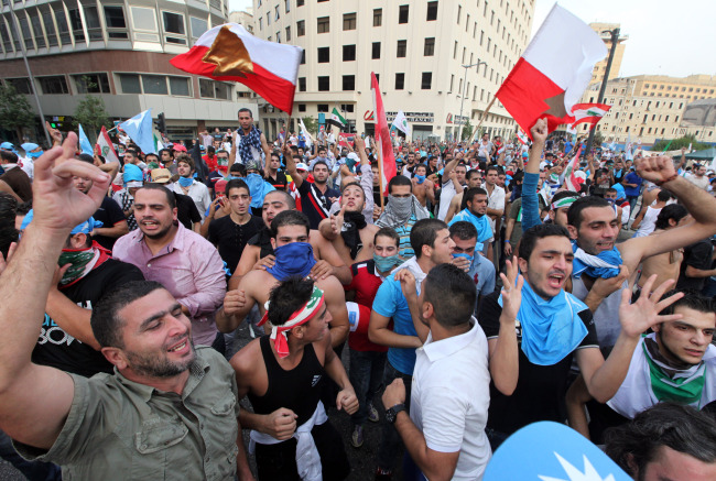 Lebanese protesters chant slogans against the Lebanese government after the funeral of Brig. Gen. Wissam al-Hassan, who was assassinated on Friday by a car bomb, in Beirut on Sunday.   AP-Yonhap News