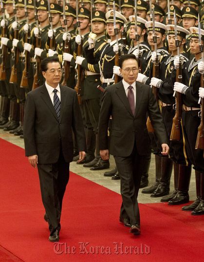 President Lee Myung-bak (right) and Chinese President Hu Jintao inspect an honor guard prior to their summit in Beijing in January. (AP-Yonhap News)