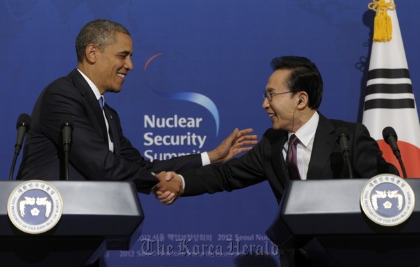 President Lee Myung-bak (right) and his U.S. counterpart Barack Obama shake hands during a news conference at Cheong Wa Dae in Seoul on March 26. (AP-Yonhap News)