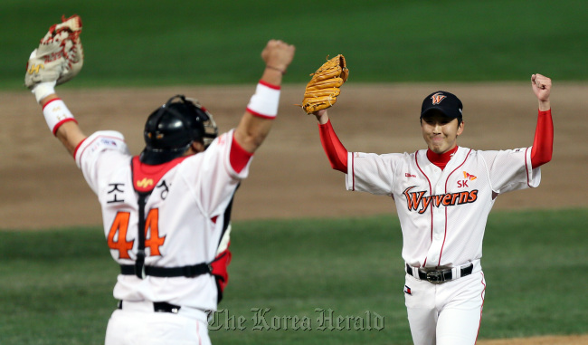 The SK Wyverns' pitcher Jung Woo-ram (right) cheers with catcher Cho In-sung after their team beat the Lotte Giants 6-3 to reach the championship final on Monday in Incheon. (Yonhap News)