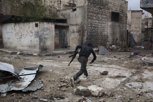 A Syrian rebel runs across a street to dodge sniper fire in the Karm al-Jabal district of the northern city of Aleppo on Monday.   AFP-Yonhap News