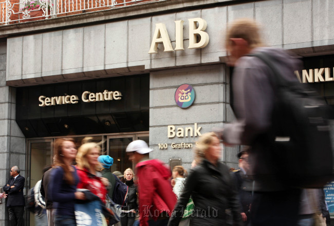 Pedestrians pass a branch of the Allied Irish Bank in Grafton Street, Dublin.   Bloomberg
Pedestrians pass a branch of the Allied Irish Bank in Grafton Street, Dublin.   Bloomberg