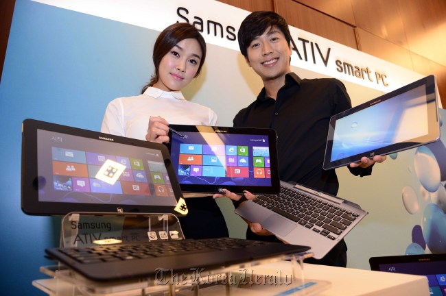 Models pose with Samsung ATIV Smart PC at a ceremony in Seoul on Wednesday.   Park Hae-mook/The Korea Herald