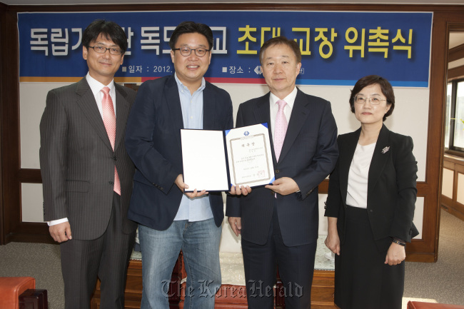 Seo Kyoung-duk (left), professor of Sungshin Women’s University, holds a letter of appointment with Kim Nung-jin, president of the Independence Hall of Korea, on Sunday after being named as the first principal of Dokdo School to be opened in the hall on March 1, 2013.   Independence Hall of Korea