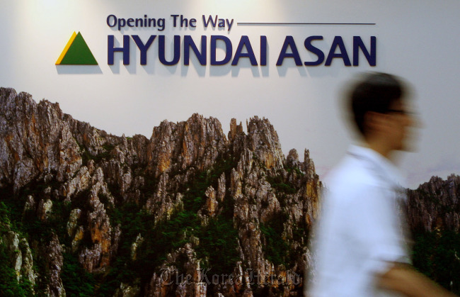 A man walks past the logo for Hyundai Asan Corp. at the company’s offices in Seoul.   Bloomberg