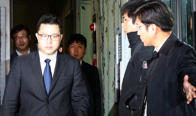 President Lee Myung-bak’s son Lee Si-hyung (left) leaves the Seoul office of the independent counsel on Friday. (Yonhap News)