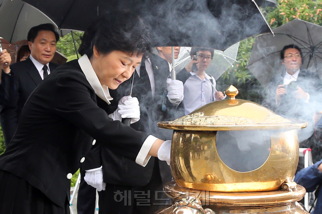 박정희 전 대통령이 서거한 ‘10ㆍ26 사태’ 33주년을 맞은 26일, 박근혜 새누리당 대선 후보가 서울 동작동 국립서울현충원을 찾아 아버지를 추모했다. 비슷한 시각, 문재인 민주당 후보는 안중근 의사 효창묘역을, 안철수 무소속 후보는 마산 국립3ㆍ15민주묘지를 참배하면서 과거사 논쟁에 불을 붙였다. 박 후보 사진은 지난 8월 대선 후보 확정 뒤 아버지 묘역을 참배하는 모습.  박현구 기자/phko@ㆍ[연합뉴스]