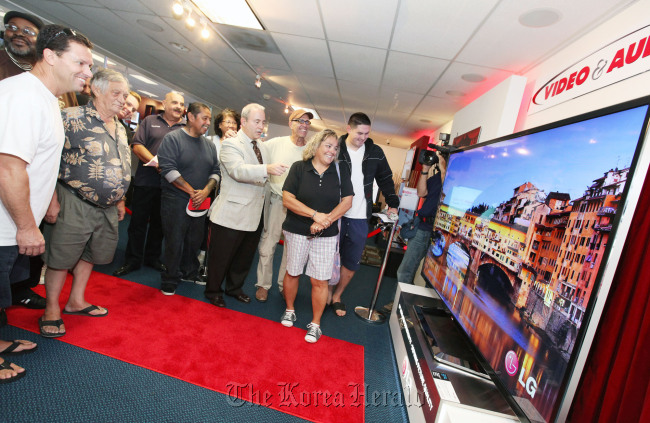 Electronics-related officials and customers flock to LG’s 84-inch ultra HD TV launch at U.S. electronic devices retailer Video & Audio Center on Friday.   LGE
