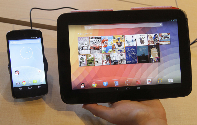 The Nexus 4 smartphone (left) and the Nexus 10 tablet are shown by Randall Safara of Google at a Google announcement in San Francisco on Monday.   AP-Yonhap News