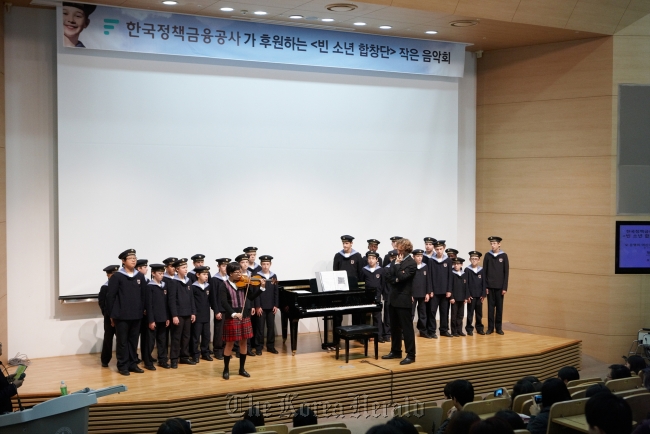 Vienna Boys Choir members listen to Park Na-eun, a leukemia patient, play the violin at the Seoul National University Hospital on Monday.   Credia