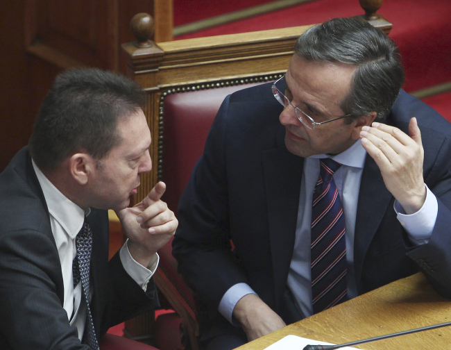 야니스 스투나라스(좌/Yannis Stournaras/교수),안토니스 사마라스(Antonis Samaras/정치인/그리스총리)
Greece’s Prime Minister Antonis Samaras (right) speaks with Greece’s Finance Minister Yannis Stournaras during a vote on a privatization bill at the Greek parliament in Athens on Wednesday.   AP-Yonhap News