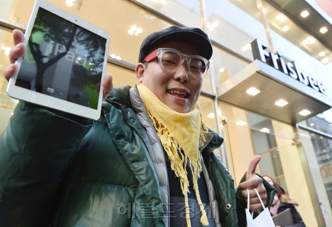 First customer Song Tae-min shows off his newly purchased iPad mini in front of the Apple Store in Myeong-dong, downtown Seoul, on Friday.   Lee Sang-sub/The Korea Herald