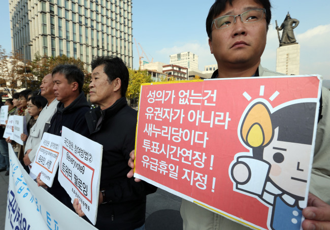 Civic activists hold a rally demanding the extension of voting hours in downtown Seoul on Tuesday.   Yonhap News
