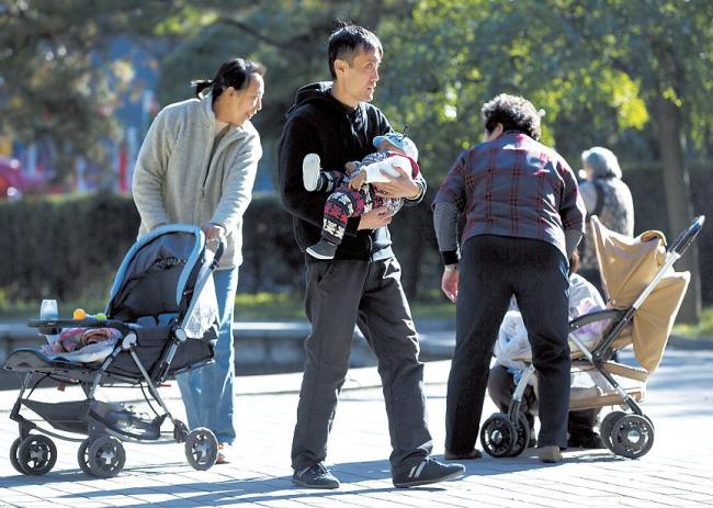 Chinese families bring their babies to the Ritan Park in Beijing. AP-Yonhap News