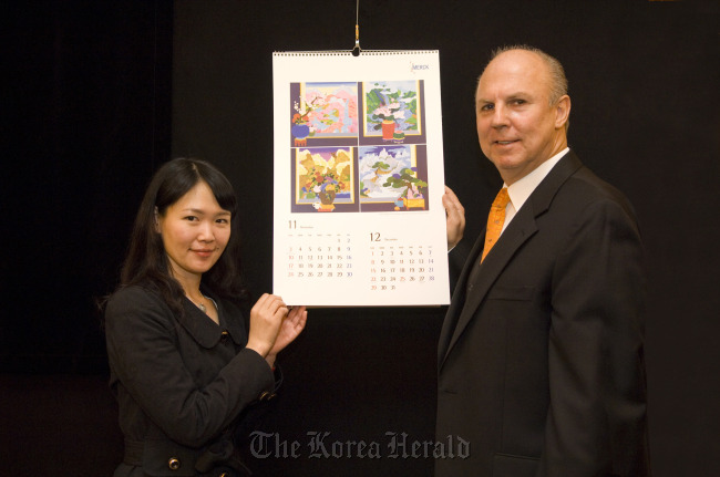 Merck Korea CEO Juergen Koenig (right) and artist Kim Ji-hye introduce the company’s 2013 calendar.   Merck Korea