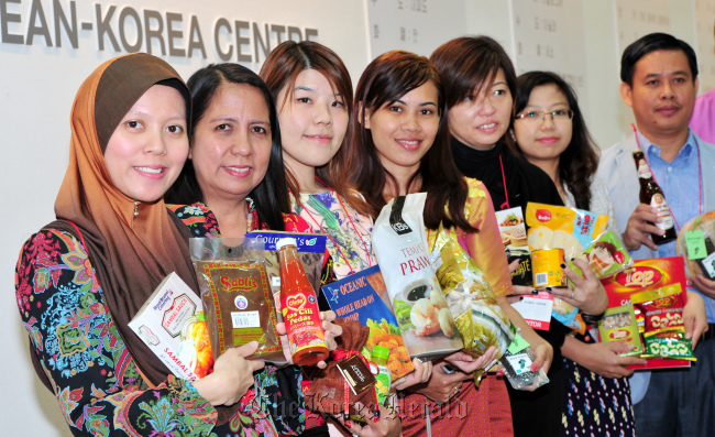 People from the Association of Southeast Asian Nations countries dress in traditional clothes and show food products of their respective countries in the ASEAN Pavilion of Food Week 2012, an international food expo, at COEX in Seoul on Tuesday.   Ahn Hoon/The Korea Herald