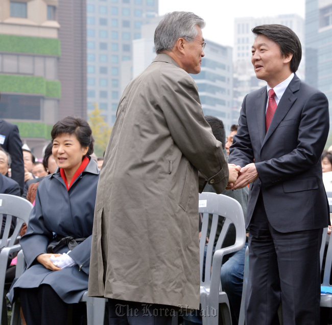 DUP candidate Moon Jae-in (center) and independent Ahn Cheol-soo (right) shake hands as Park Geun-hye of the Saenuri Party looks the other way at an event for fisheries workers in Seoul on Tuesday.   Park Hyun-koo/The Korea Herald