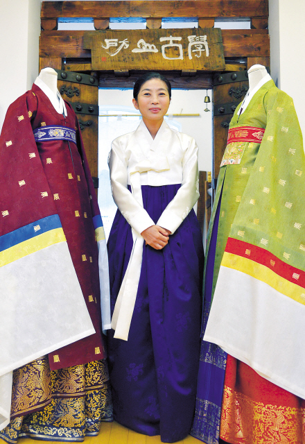 Lee Hye-soon, designer of the hanbok brand Damyeon, stands between two pieces that will be showcased at the opening art show of Art Miami on Dec. 4. (Kim Myung-sub/The Korea Herald)