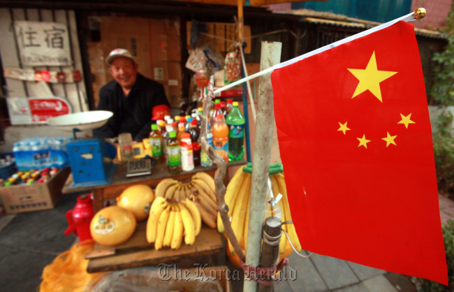 A Chinese fruit vendor displays his patriotism ahead of the upcoming elections of a new group of Chinese leaders in Beijing on Nov. 6. (UPI-Yonhap News)