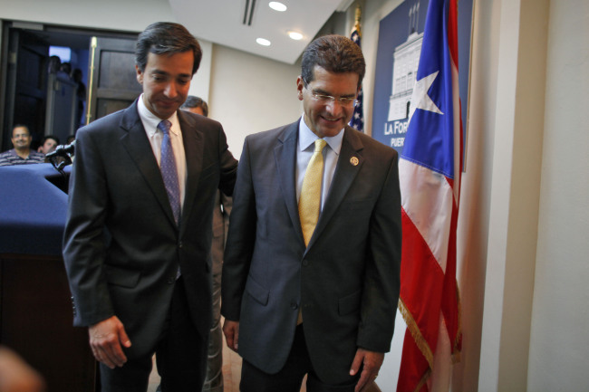 Pedro Pierluisi (right), Puerto Rico’s representative in U.S. Congress, is accompanied by Puerto Rico’s Gov. Luis Fortuno at the end of a news conference in San Juan, Puerto Rico, Wednesday.   AP-Yonhap News