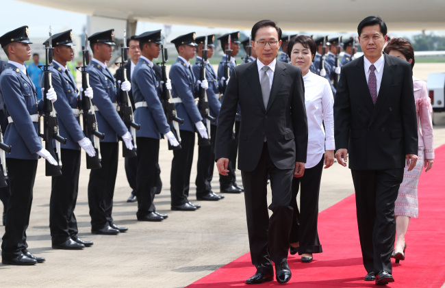 이명박(대통령)
President Lee Myung-bak (left), accompanied by Thailand’s Deputy Prime Minister Phongthep Thepkanjana, inspects a guard of honor upon his arrival at Don Mueang International Airport in Bangkok on Friday.   Yonhap News