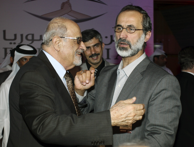 Syrian opposition figure and prominent Syrian human rights activist Haytham al-Maleh (left) congratulates Islamic preacher Moaz al-Khatib after he was elected president of the newly formed Syrian National Coalition for Opposition and Revolutionary Forces, in Doha, Qatar, Sunday.   AP-Yonhap News