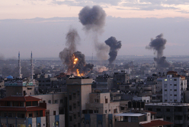 Columns of smoke rise following an Israeli air strike in Gaza City, Wednesday. (AP-Yonhap News)