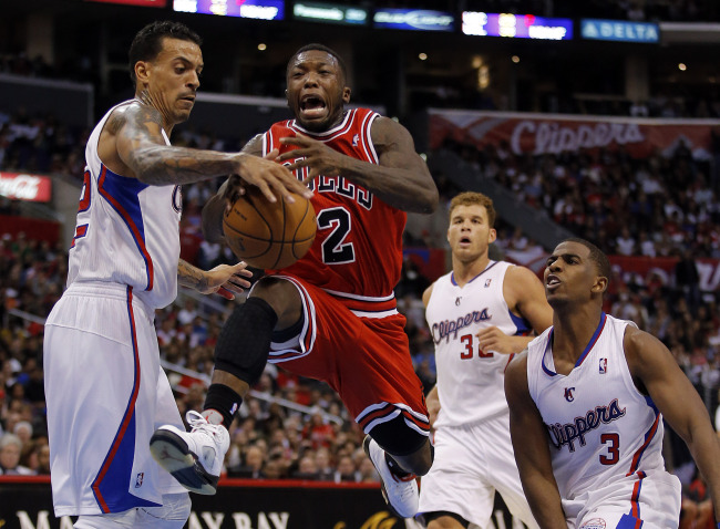 Chicago Bulls’ Nate Robinson (center) is fouled by Los Angeles Clippers’ Matt Barnes (left) as Los Angeles Clippers’ Chris Paul (right) and Blake Griffin (background right) look on in the second half of an NBA basketball game in Los Angeles on Saturday.   AP-Yonhap News