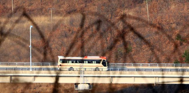 A bus carrying Hyundai Asan staff heads for North Korea on Monday. They visited Mount Geumgang to mark the 14th anniversary of the start of the now suspended inter-Korean tour program.   Yonhap News