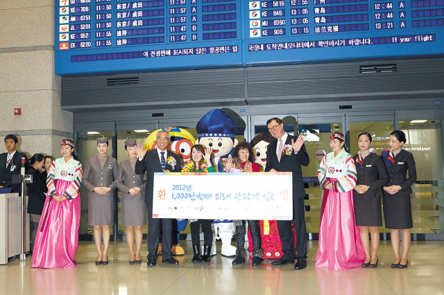 Korea’s 10 millionth visitor Li Tingting (second
from left) and his mother Ye Shufang (third from left) pose for a photo
with Culture Minister Choe Kwang-shik (left) and CEO of The Korea
Tourism Organization Lee Charm at Incheon International Airport on
Wednesday. It’s the first time Korea has drawn 10 million visitors in a single year. (Ahn Hoon/The Korea Herald)