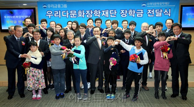 우리금융그룹(회장 이팔성)은 21일 서울 회현동 우리금융 본사에서 다문화가족 자녀 308명에게 장학금 1억5000만원을 전달하는 ‘다문화가족 자녀 장학금 전달식’을 열었다고 22일 밝혔다. 이팔성 우리다문화장학재단 이사장(앞줄 왼쪽에서 다섯번째)과 우리금융그룹 임원들이 장학생들과 기념촬영을 하고 있다.  [사진제공=우리금융]