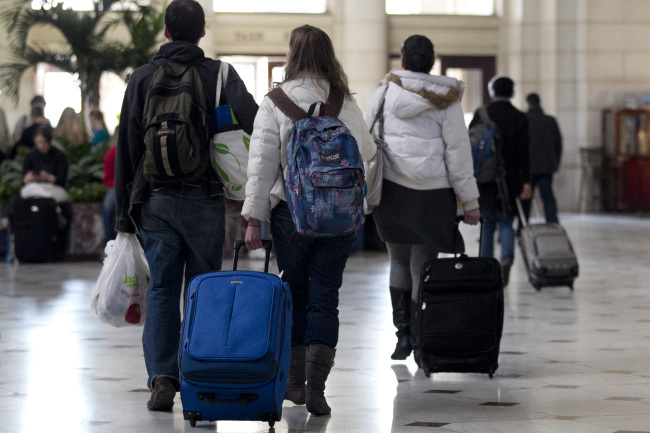 Travelers pull luggage while walking out of Union Station in Washington, D.C., Wednesday.   Bloomberg